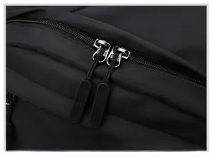 Detail of durable dual-way zippers and textured nylon fabric on black laptop backpack