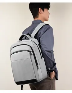 Detail of grey business backpack showing side USB charging port and zipper compartment