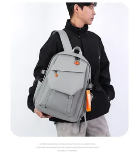 Détail du sac à dos gris clair avec sangles orange décoratives et fermetures éclair tendance
