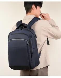 Detail showing the USB charging port and gray reflective safety strip on a navy backpack