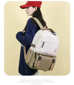 Détail du sac à dos kaki et crème avec poches avant à boucle et imprimé de lettres