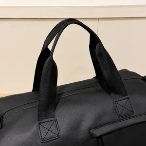 Macro-opname van versterkte handgrepen met kruisstiksels op zwarte nylon reistas