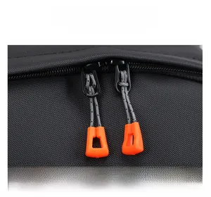 Détail de fermetures éclair en métal avec tirettes orange sur un sac à dos ordinateur
