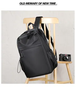 Detail view of the black minimalist backpack featuring side pockets and zippers on a chair