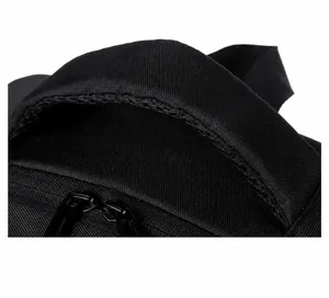 Close-up of padded top handle with breathable mesh and metal zippers on black backpack