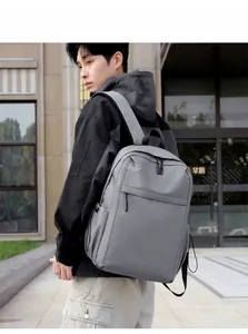 Side view of the minimalist grey waterproof backpack shown on a model outdoors
