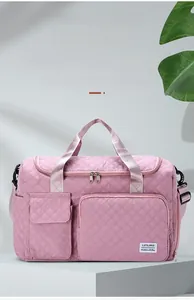 Pink quilted travel bag featuring front zip pockets and dedicated storage compartments