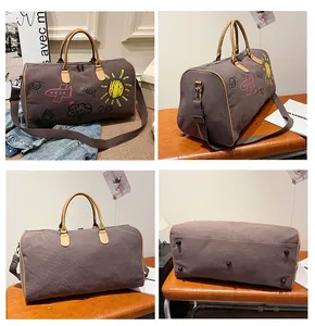 Vue détaillée du sac de voyage graffiti montrant la toile durable et les clous de fond en métal