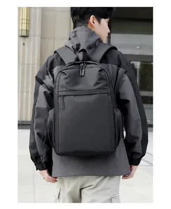 Outdoor shot showing back detail and padded shoulder straps of the black minimalist backpack