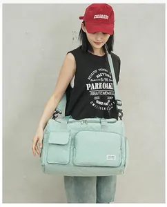 Close-up of mint green quilted travel bag showing dual front pockets and shoulder strap