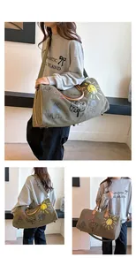 Vue triple d'un sac de voyage en toile graffiti avec poignées en cuir et bandoulière