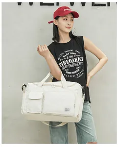 Detail view of cream quilted travel bag with large capacity pockets and shoulder strap