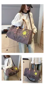 Détails des motifs graffiti et des poignées en cuir du sac de voyage de style militaire