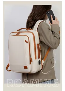 Detail of the cream travel backpack showing the USB charging port and brown accents