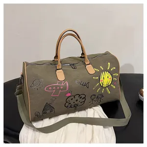 Détail du sac de voyage en toile avec motifs graffiti colorés et anses en cuir