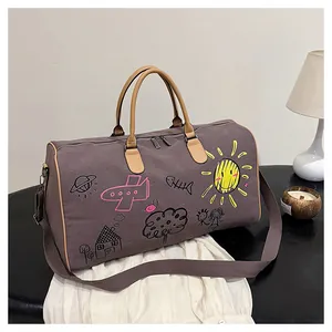 Détail du sac de voyage avec motifs graffitis colorés et poignées en cuir élégantes