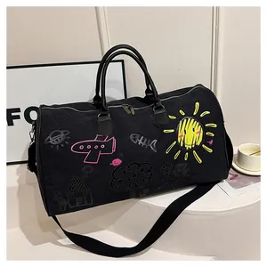 Detail of black graffiti duffel bag with colorful hand-drawn prints on a white stand
