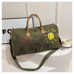 Detail of olive green canvas travel bag with colorful graffiti and leather handles