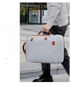 Close-up of light grey business backpack with premium brown leather handles and zipper details