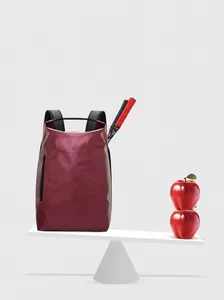 Detailansicht des leichten 0,33 kg weinroten Rucksacks, der auf einer Waage ausbalanciert ist