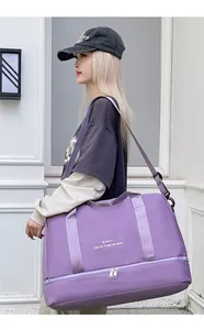Detalle de bolsa de viaje morada con compartimento inferior impermeable y correa de hombro