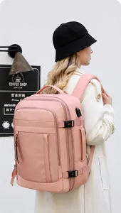 Detalle de una mochila de viaje rosa impermeable con puerto USB y hebilla lateral