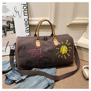 Détail du sac de voyage en toile avec motifs graffiti colorés et anses en cuir