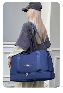 Detalle de la bolsa de viaje azul marino con compartimento para zapatos y texto de marca