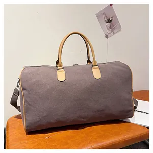 Vue détaillée du sac de voyage en toile marron foncé avec poignées et sangles en cuir PU brun