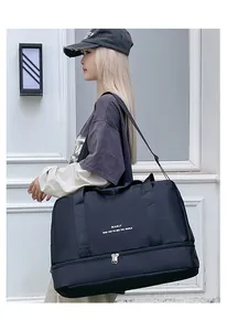 Detalle de bolsa de viaje negra con tela impermeable y compartimento inferior para zapatos