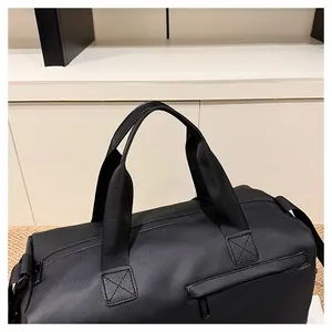 Detail van de versterkte X-stiksel handgrepen en waterdichte zwarte nylon stof van de reistas