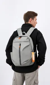 Detail of grey waterproof backpack showing orange fashion tag and side pocket