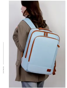 Side view of light blue travel backpack with brown leather trim and wide straps