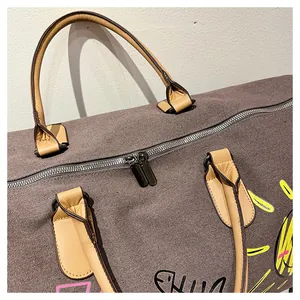 Gros plan du sac de voyage graffiti montrant les fermetures éclair et les poignées en cuir