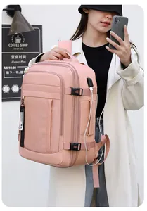 Mochila de viaje rosa con puerto USB y asa lateral, mostrada por una modelo