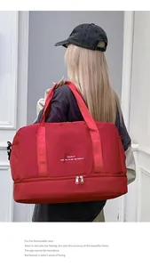 Detalle de bolsa de viaje roja grande con compartimento inferior para zapatos y ropa