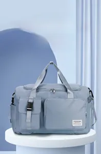 Dettaglio borsa da viaggio azzurra che mostra il tessuto nylon e l'etichetta del marchio
