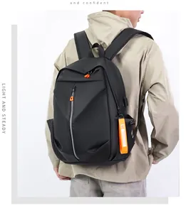 Detail of black tactical backpack featuring USB port and orange fashion ribbon strap