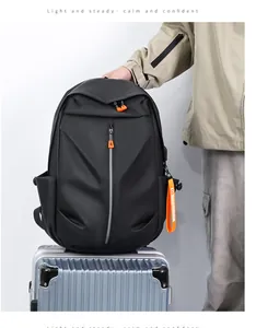 Waterproof black backpack with orange zipper accents on a silver metal suitcase