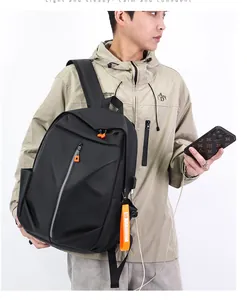Close-up of black waterproof business backpack with USB port and orange zipper details