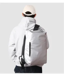 Wasserdichter silberner Sportrucksack im Detail an einem Modell im grauen Urban-Stil