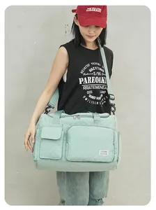 Lifestyle view of a large mint green quilted travel bag with shoes compartment and strap