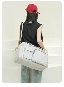 Detail of grey quilted travel bag with diamond patterns and multiple storage pockets