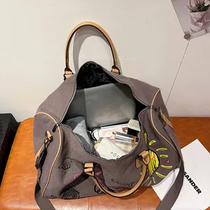 Graffiti canvas travel bag with large capacity for laptop and gear, shown on brown bench