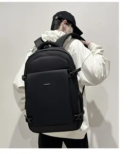 Close-up of matte black waterproof nylon backpack with metal logo and compression straps