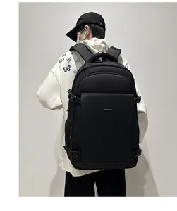Rear view of a large black waterproof business backpack worn by a model in a white studio