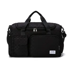 Black quilted travel bag with large capacity and shoulder strap on white background
