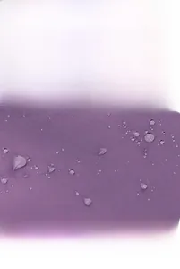 Dettaglio del tessuto oxford viola impermeabile con gocce d'acqua sulla borsa sportiva