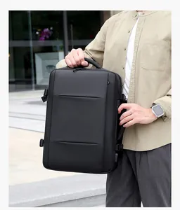 Detail of waterproof black business backpack showing dual handles and side compression straps
