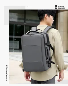 Gray expandable travel backpack with side handle and USB port shown on a male model